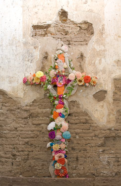 Cross in the church at Tumacacori National Historic Site decorated with paper flowers